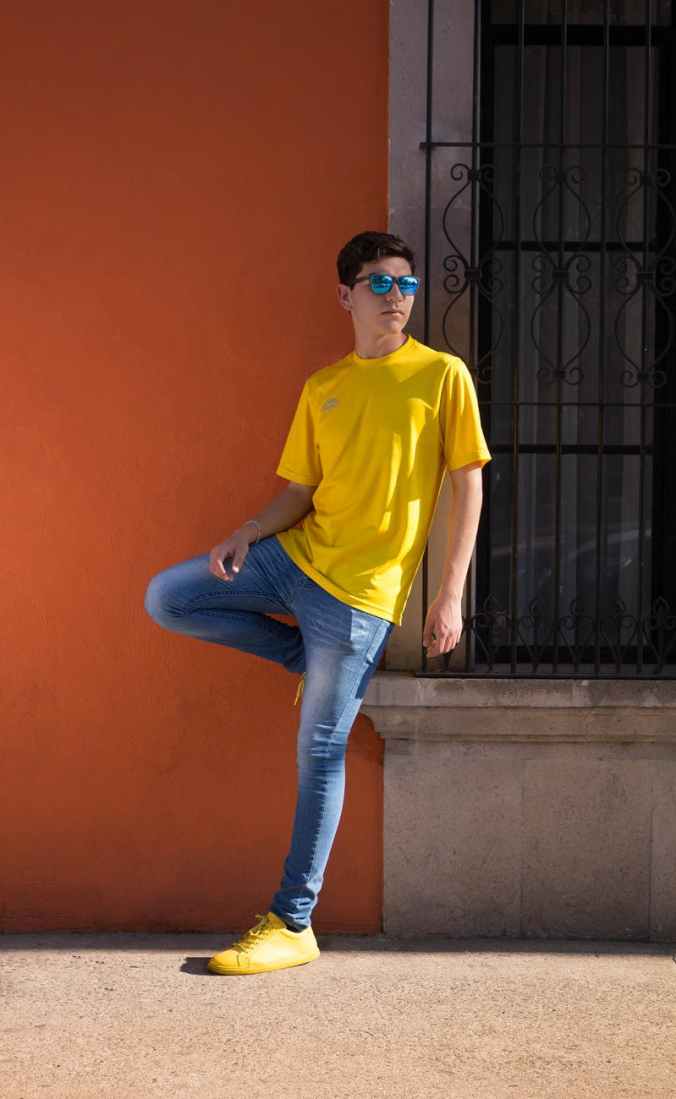 man wearing yellow crew neck t shirt and blue denim jeans