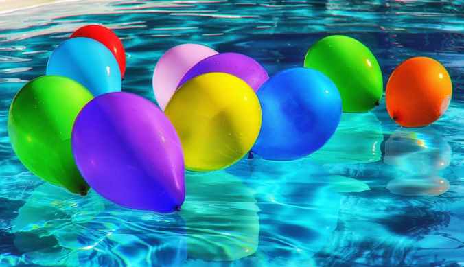 purple yellow and blue balloon on swimming pool