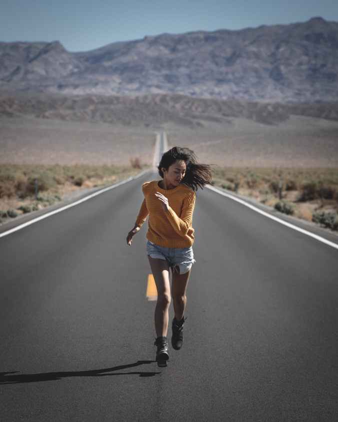 photo of woman running on road