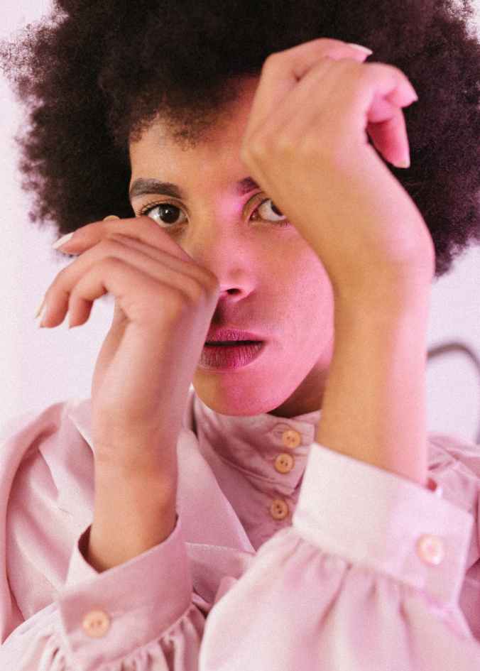 graceful androgynous man in shirt covering face with hands